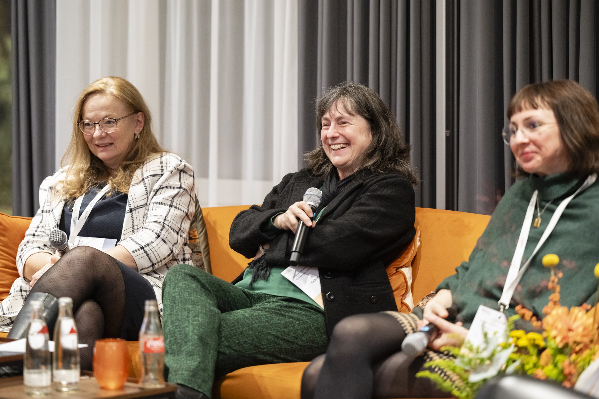 Drei Frauen sitzen auf einer Couch.