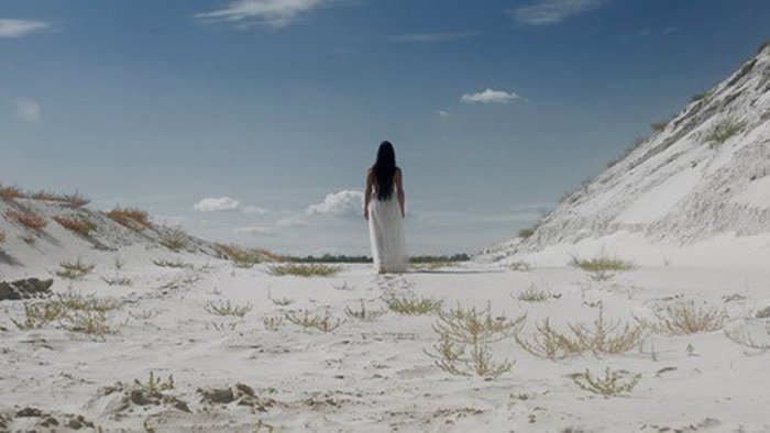Eine Frau läuft durch weißen Dünensand