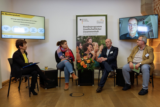 Fünf Personen sitzen in einem Halbkreis.