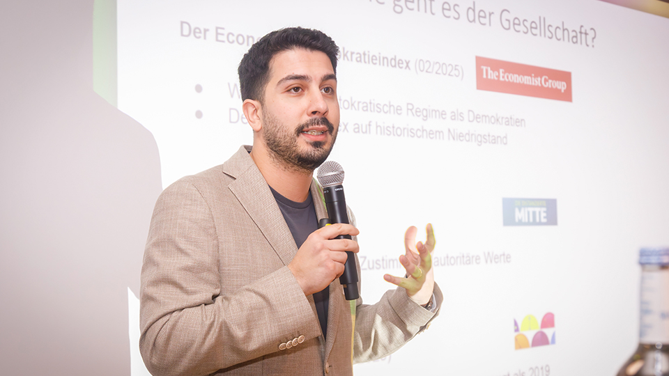 Ein Mann hält ein Mikrofon in der Hand.