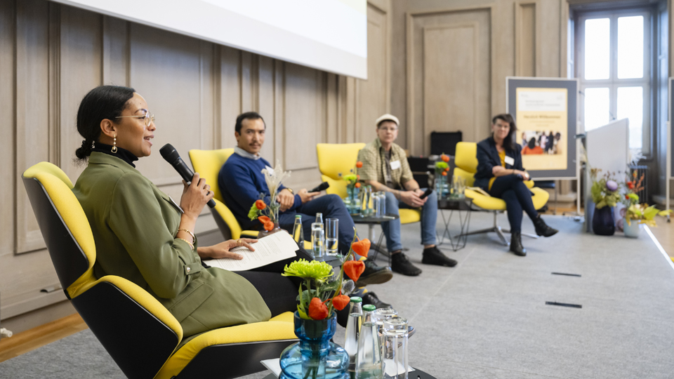 Drei Frauen und ein Mann im Gespräch auf dem Podium