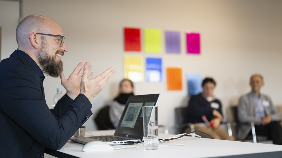 Ein Dozent spricht zu Workshop-Teilnehmenden.