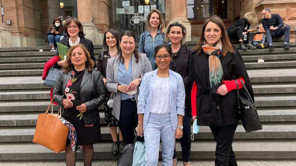 Eine Gruppe von Frauen steht vor einem Gebäude.